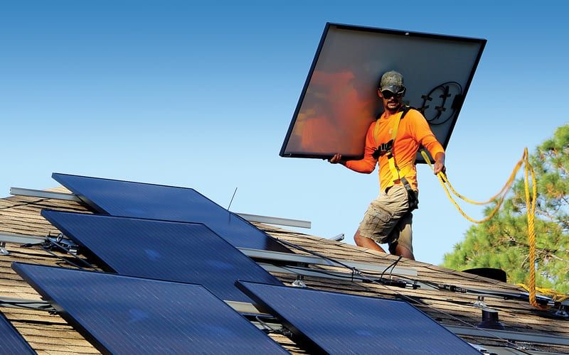 Atlantic Key Energy installers place solar panels on a home in Navarre. Home solar is growing in popularity.