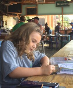 Encompass Church of Navarre members write letters of encouragement to military members during a regular meeting Wednesday night at TC’s Front Porch. Encompass is a relatively new church in Navarre and has yet to find a permanent location.